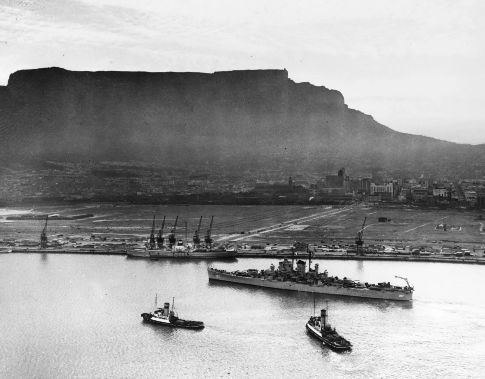 Der leichte Kreuzer USS Huntington (CL-107) bei der Anfahrt auf Berth M, Duncan Docks, Kapstadt, mit Tafelberg im Hintergrund, 15. Oktober 1948